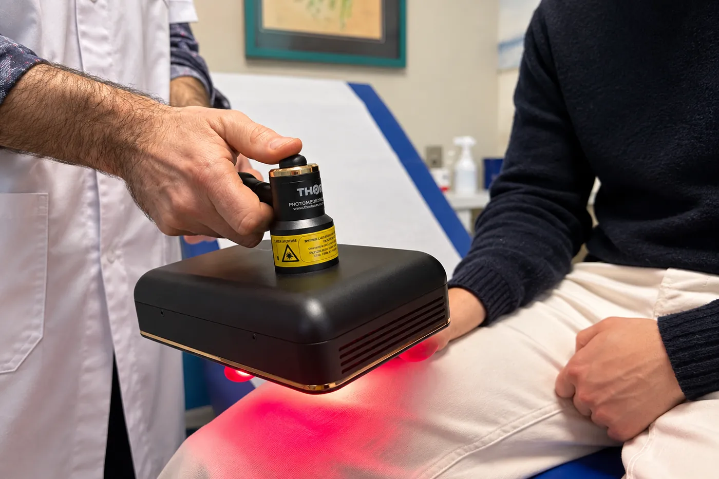 Sonde de photobiomodulation appliquée sur la main d’un patient